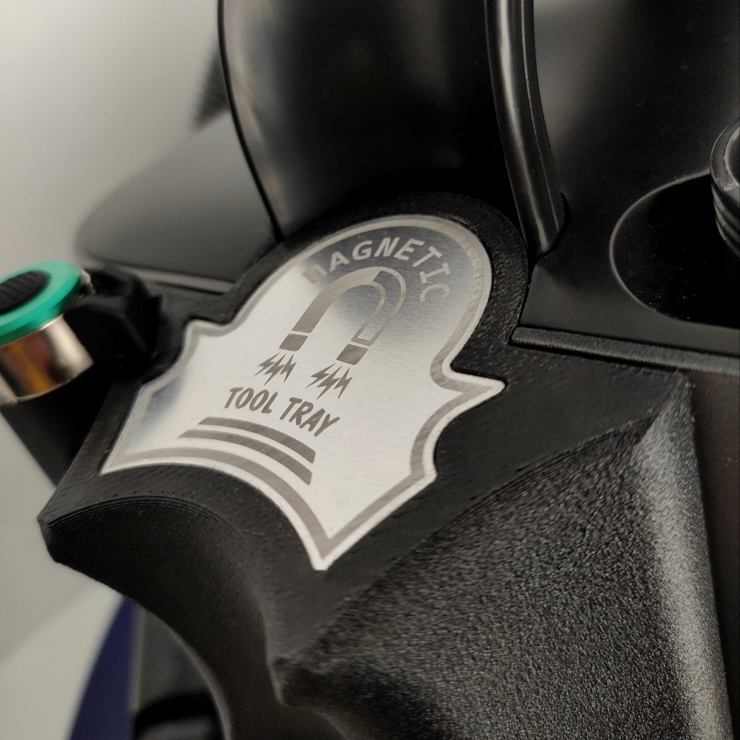 Picture shows close-up of a silver magnetic bit tray designed to hold one or two podiatry burrs, with the black Onyx extraction drill softly blurred behind—highlighting podiatry instruments and foot care supplies.
