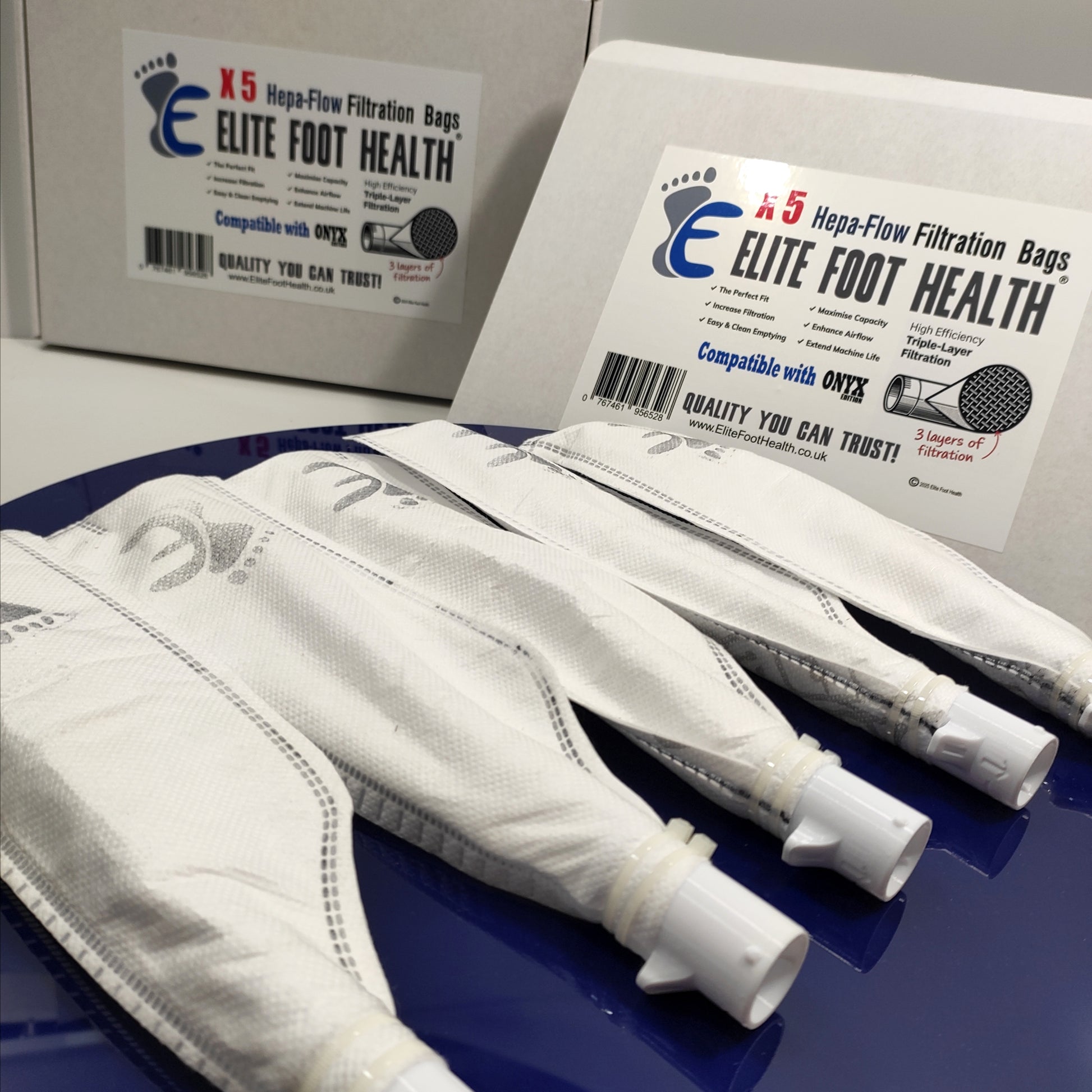Elite Foot Health filtration bags with packaging on a blue surface