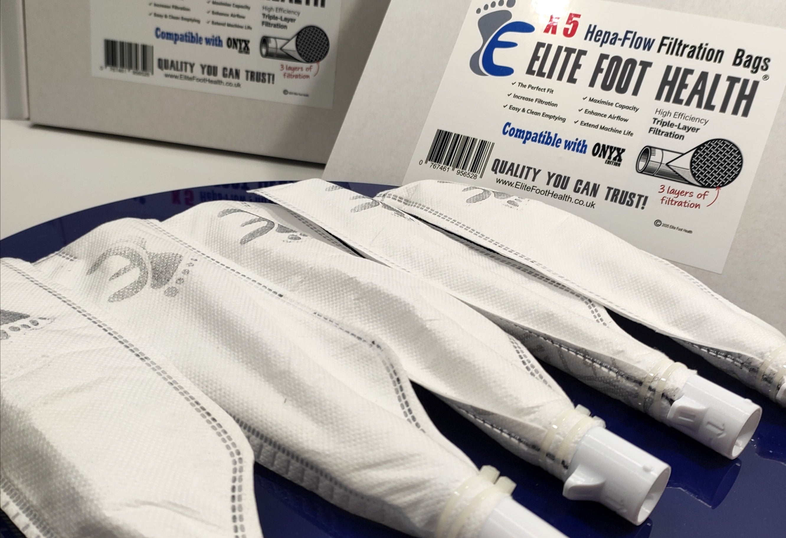 Elite Foot Health filtration bags with packaging on a blue surface