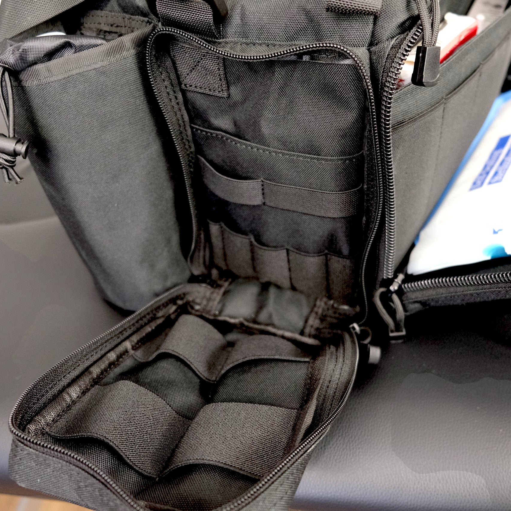 Open tactical backpack with compartments on a gray surface